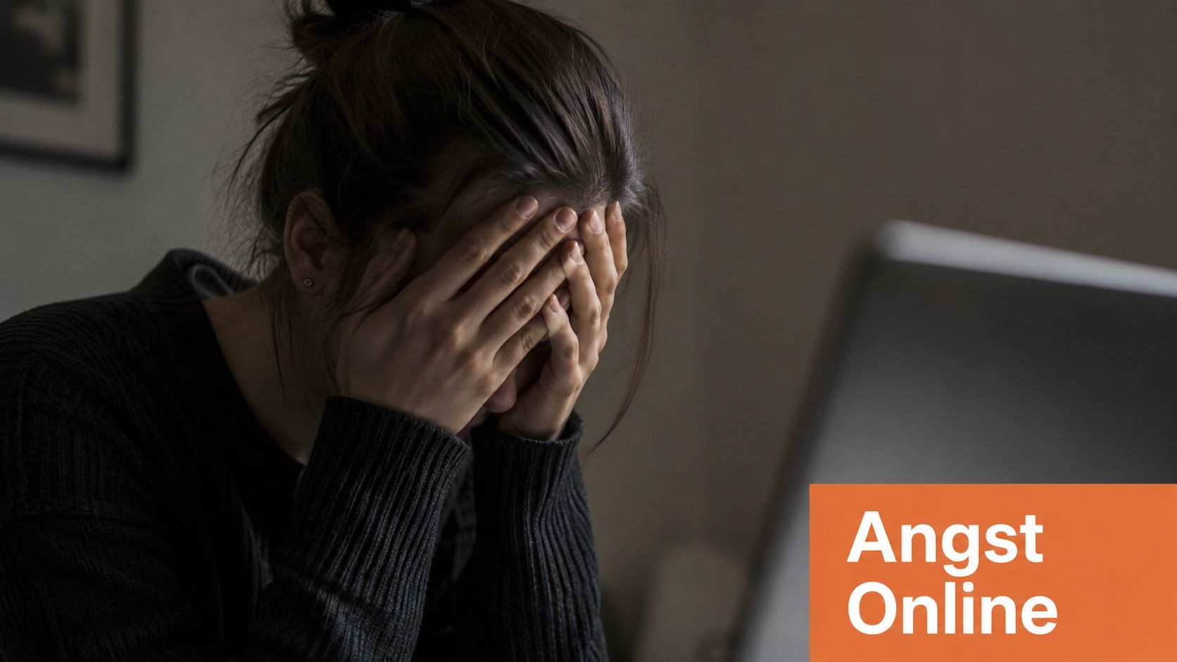 Eine Frau hält sich verzweifelt die Hände vors Gesicht, während sie vor einem Laptop sitzt.